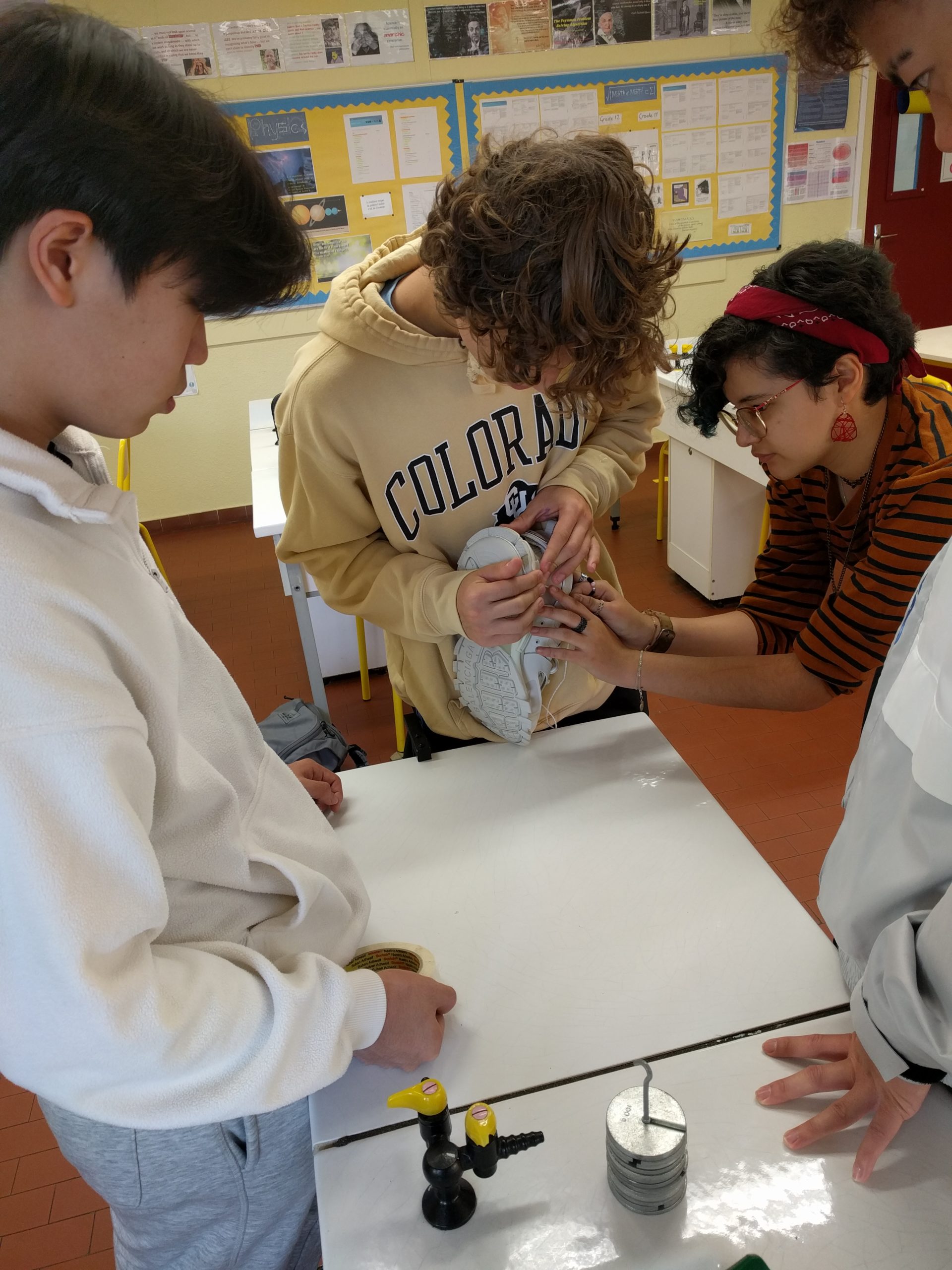 Grade 11 students holding a shoe and setting up their experiment