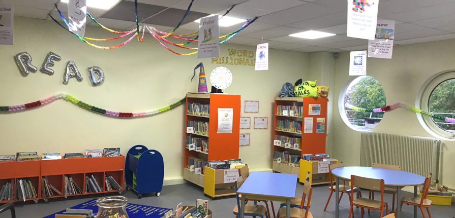 a decorated library with stocked shelves, tables and chairs