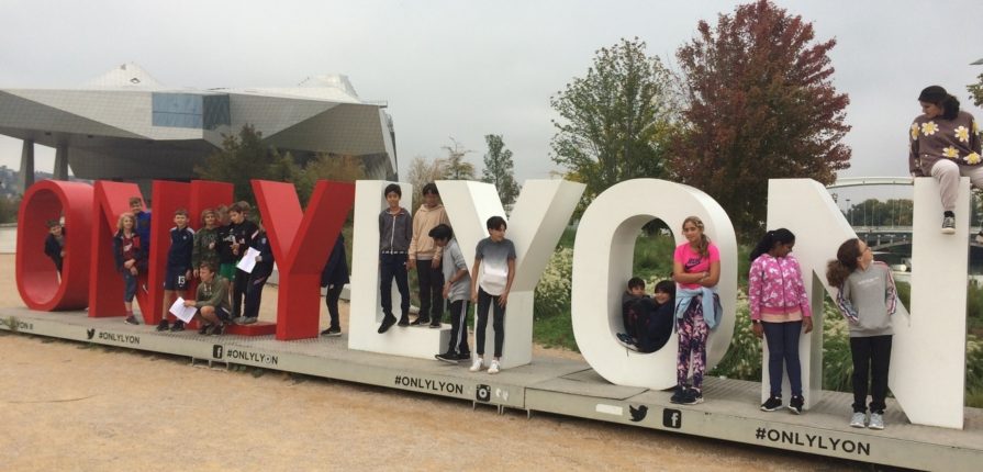 Students posing with the "OnlyLyon" sign in the Confluence area of Lyon
