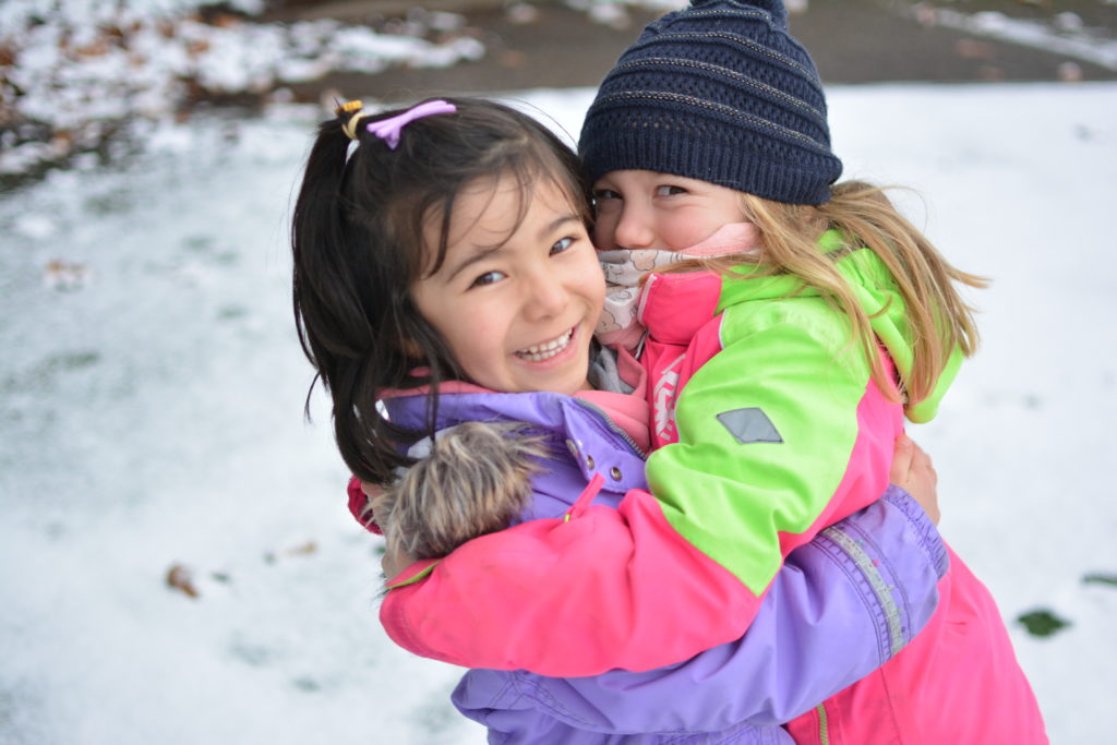 2 kindergarten girls playing in the snow