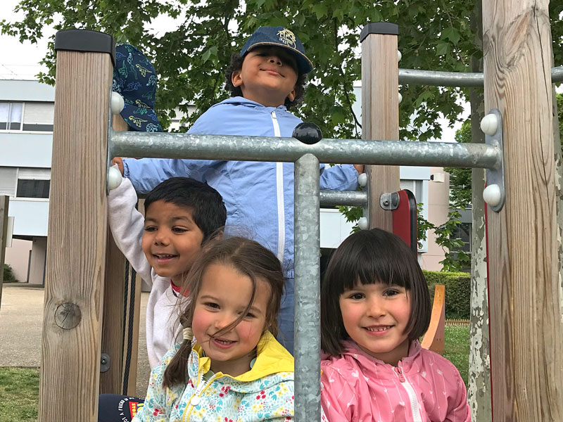 4 students climbing on a play structure