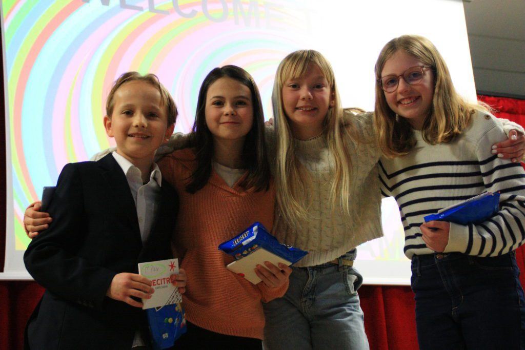 The 4 winners of the poetry slam posing on stage.