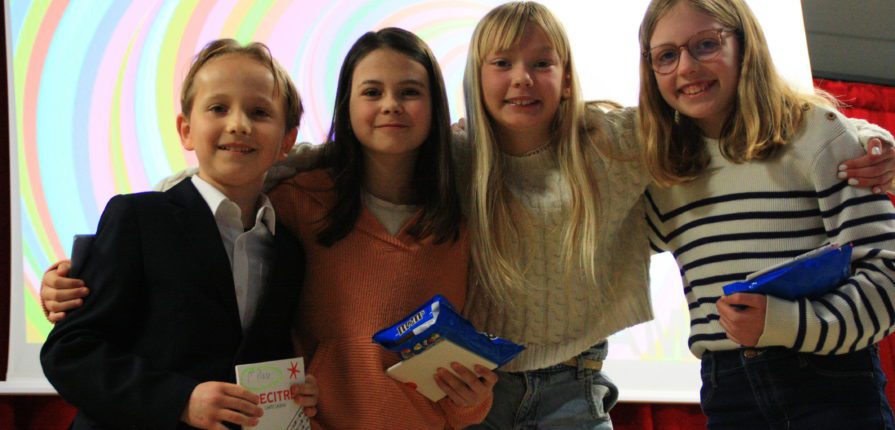 The 4 winners of the poetry slam posing on stage.