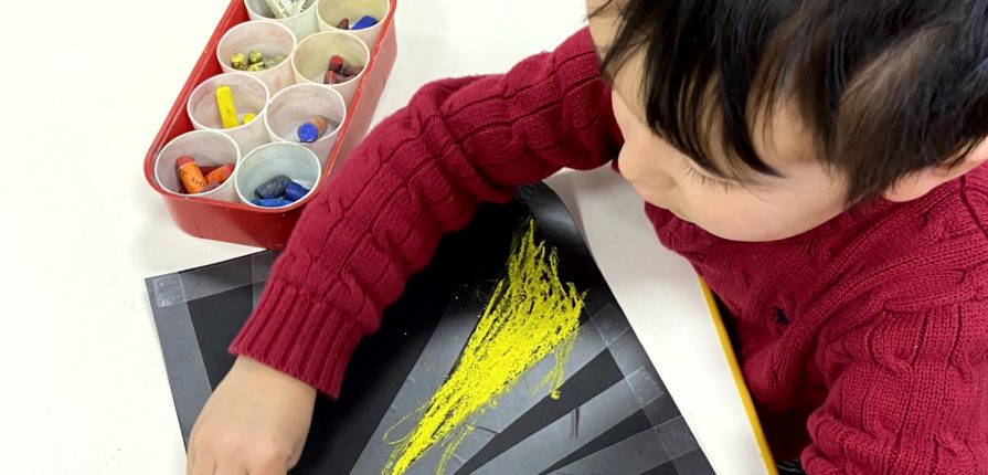 Kindergarten student using pastels to make art