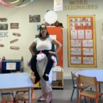 The ISL primary librarian posing in her costume in the library for book week