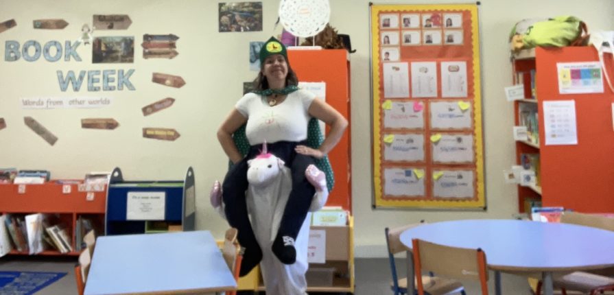 The ISL primary librarian posing in her costume in the library for book week