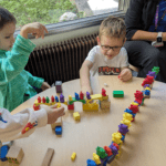 Kindergarten students building bridges with blocks and testing them with colourful teddy bear figures