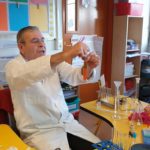 A science teacher mixing liquids in a test tube in a primary classroom