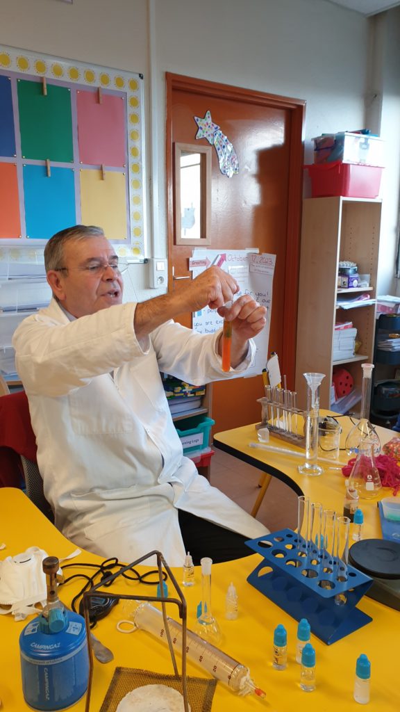 A science teacher mixing liquids in a test tube in a primary classroom