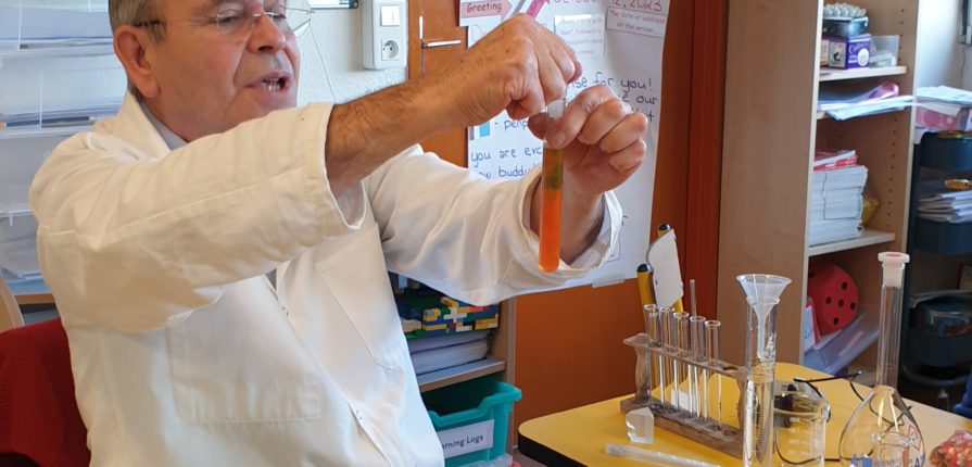 A science teacher mixing liquids in a test tube in a primary classroom