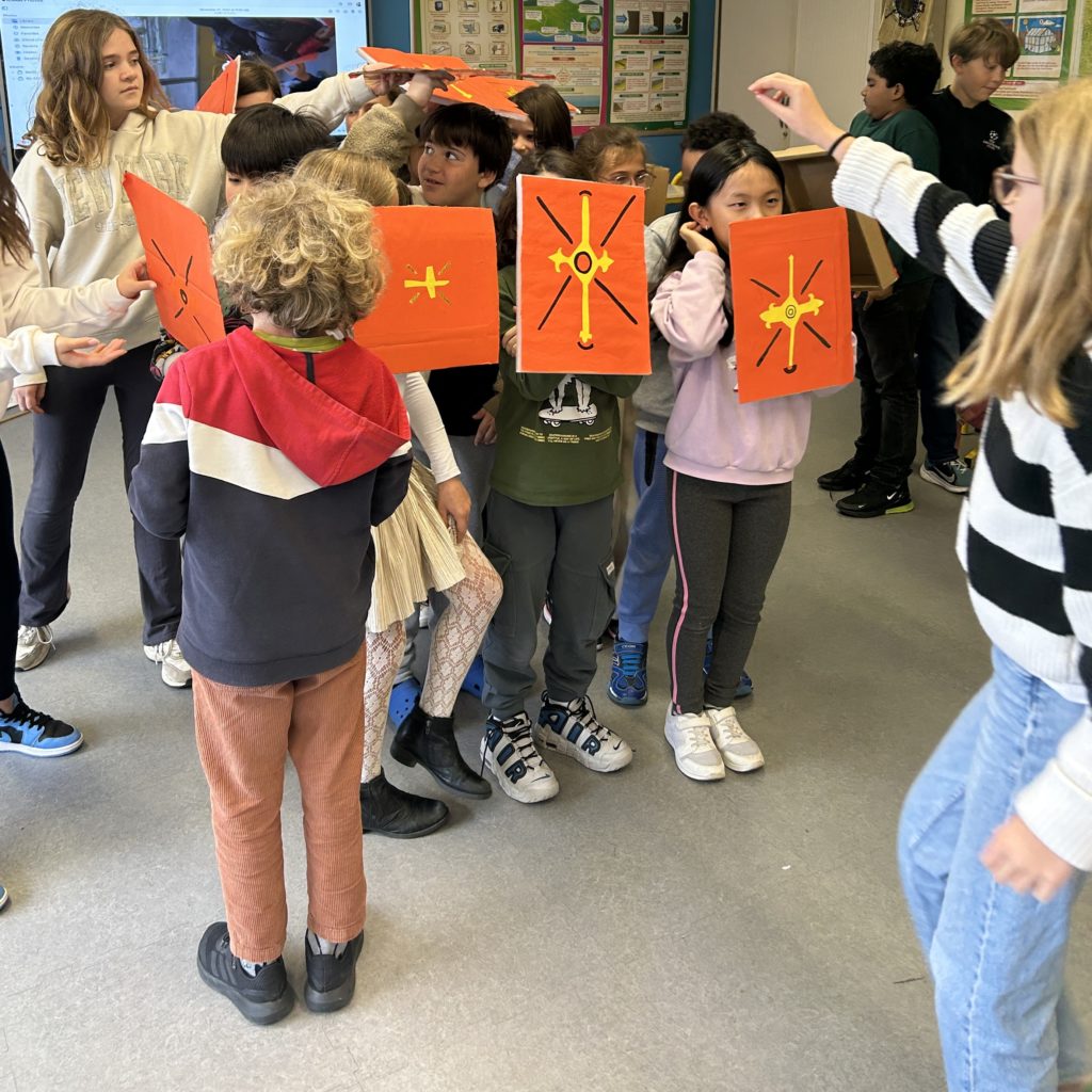 students holding Roman shields, made out of paper and cardboard
