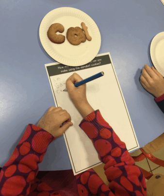 Student practicing writing with cookies shaped as letters