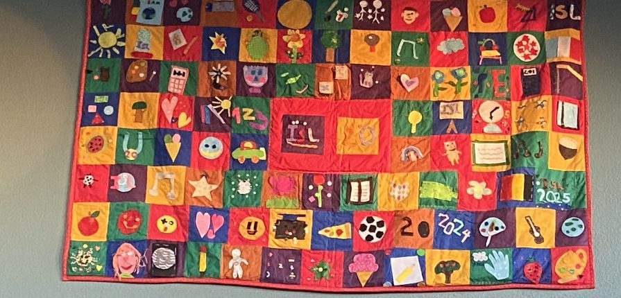 ISL 20th anniversary quilt hanging on a wall