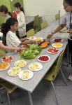 Students making plates of food from the produce they purchased at the market
