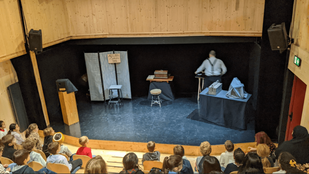 students sitting in a theater facing the stage