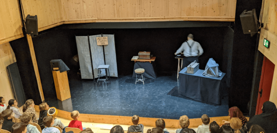 students sitting in a theater facing the stage