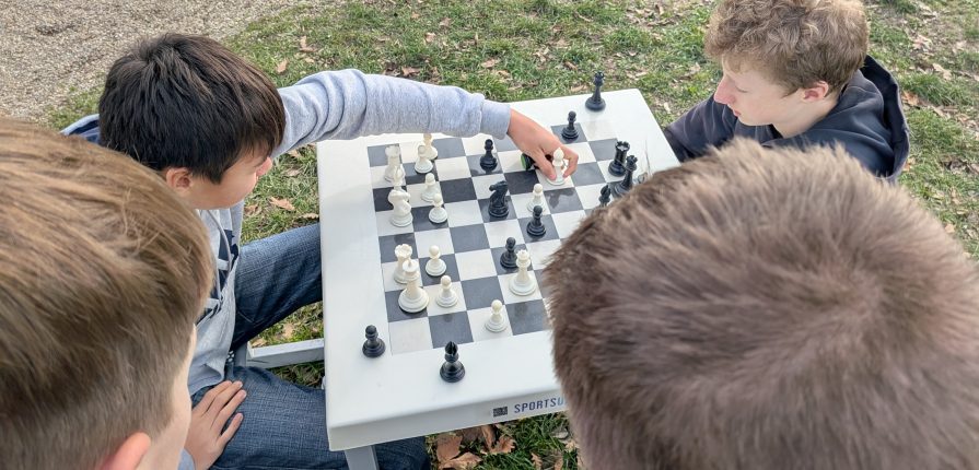 students playing chess on an outdoor chess board