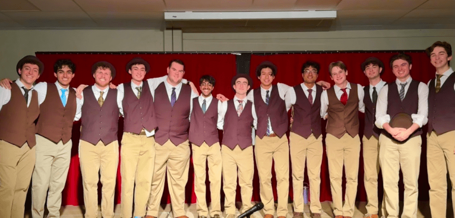 Members of the Brown Derbies posting on stage in the ISL Auditorium