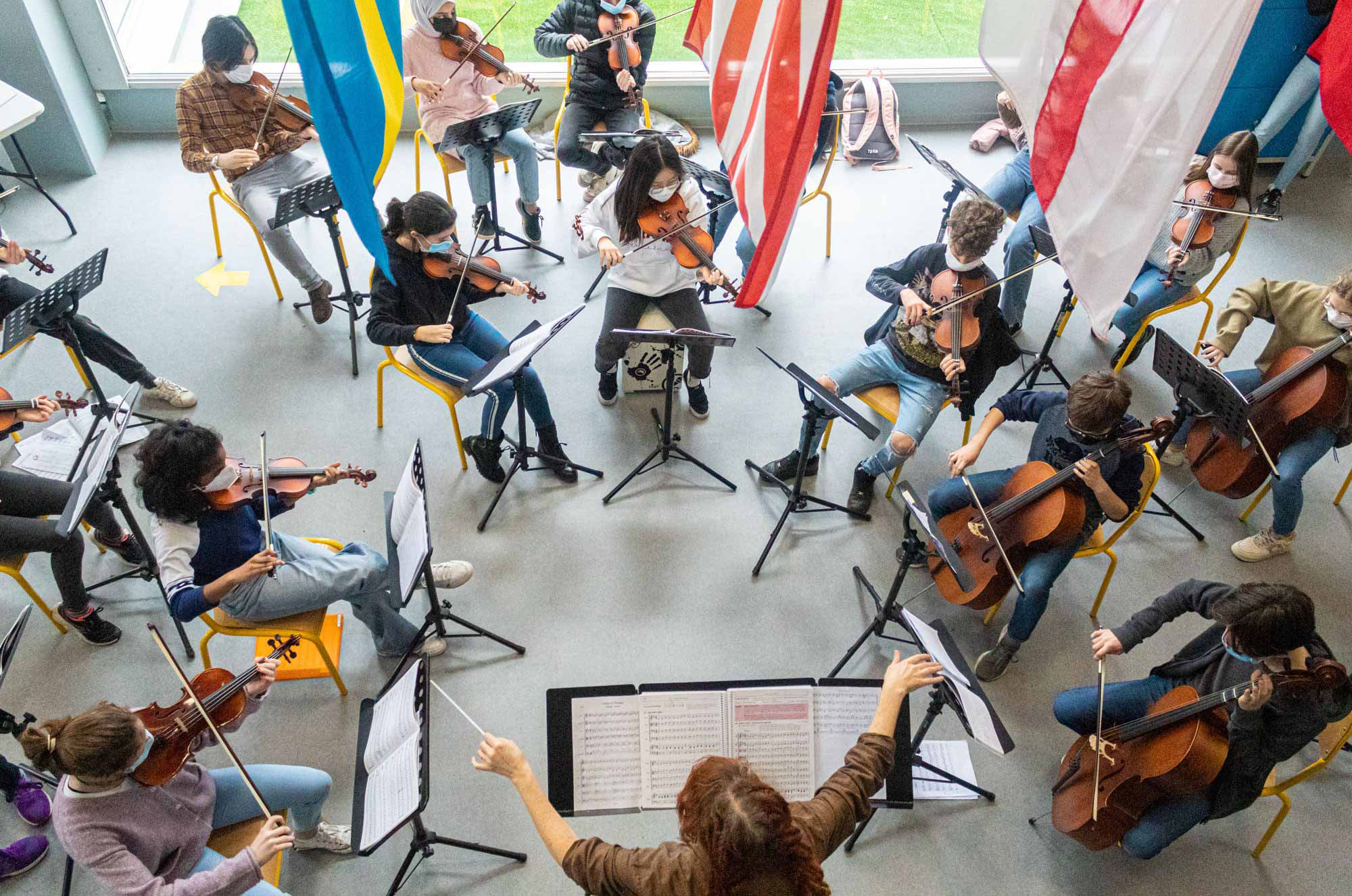 photo from above of an ISL teacher conducting a student orchestra